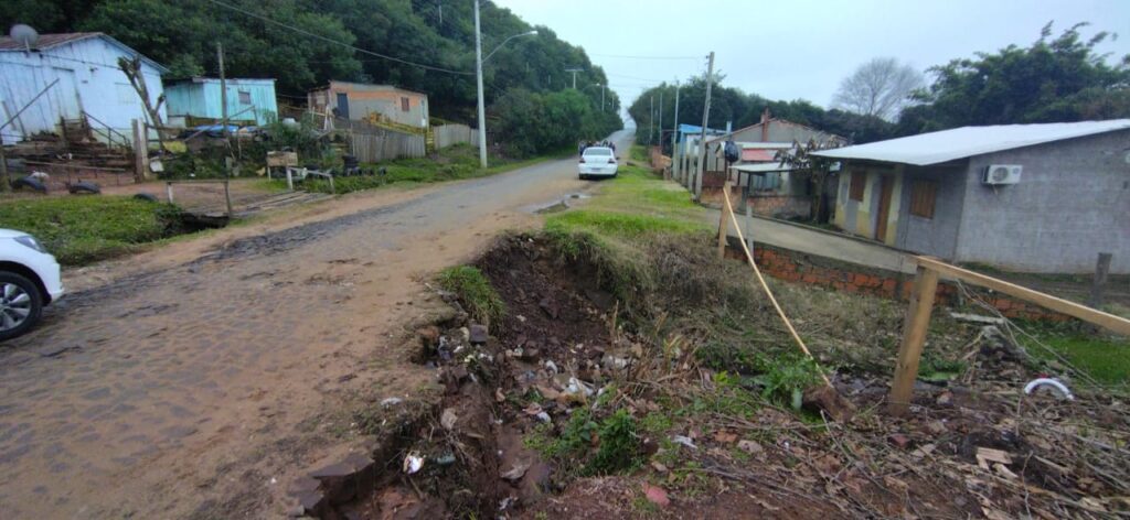 A reportagem do Jornal A Plateia foi contatada nesta semana por moradores da região do Cerro do Registro, no bairro Prado, para conferir a situação da rua Irmão Lino de Azevedo onde uma cratera se formou, próxima à residência de número 475 e vem preocupando quem transita na localidade. Na manhã de quinta-feira (14), a reportagem esteve no local e confirmou que o calçamento da rua está desmoronando pela ação da água que escorre de forma irregular vinda do cerro. O bueiro que existia no local está quebrado e soterrado com o entulho que desceu com a chuva. Segundo um morador que conversou com a reportagem e não quis se identificar, a situação está piorando a cada chuva, e isto já havia sido comunicado para a Secretaria de Obras. Após a visita no local, a reportagem procurou o secretário Dilmar Rodrigues, responsável pela Pasta, mas ele estava em viagem. Segundo Darci Carlos da Rosa Alves, secretário adjunto da Secretaria de Obras, assim que tomou conhecimento da situação por meio do Jornal A Plateia, uma equipe foi deslocada para lá para avaliar a situação, mas em virtude da forte instabilidade climática na fronteira o serviço de reparo teve que ser adiado. “Nós assistimos a live, e naquela mesma tarde uma equipe foi lá. Aquela erosão é causada por uma água que desce lá de cima do cerro. Então, um morador acabou fazendo uma contenção de pneus e em uma dessas enxurradas ela acabou se rompendo. Neste caso, a água acaba vindo por cima da rua e não por dentro da canalização. O nosso pessoal já ia começar a trabalhar lá, mas por conta da chuva o serviço teve que ser adiado. ”. O secretário adjunto garantiu que assim que as condições do tempo melhorarem o problema será resolvido. “Entre colocar um material lá para virar mais barro, e ficar a situação pior, e esperar para arrumarmos com tempo melhor, preferimos este último para realmente ficar um bom trabalho. Então, nós suspendemos o serviço. Quando melhorar, nós vamos lá e executaremos o trabalho”, encerrou.